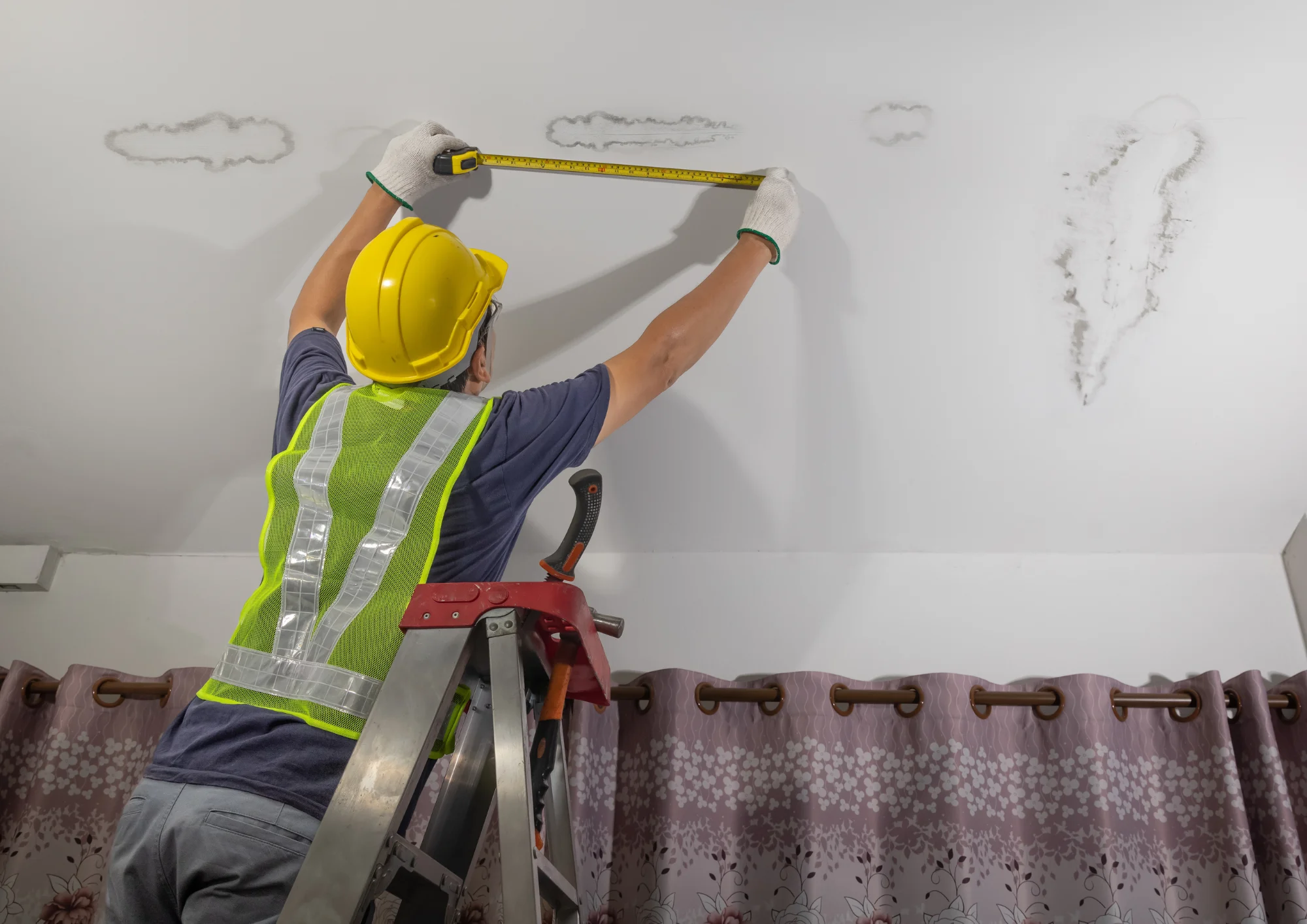 Plumber reviewing a leaking wall pipe to determine insurance coverage