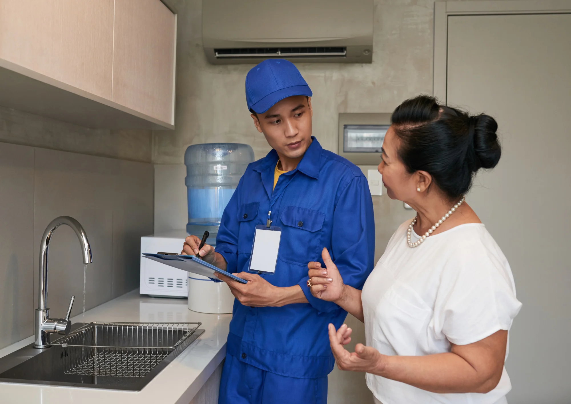 Homeowner discussing common hidden plumbing costs with a professional plumber in Rockwall, TX